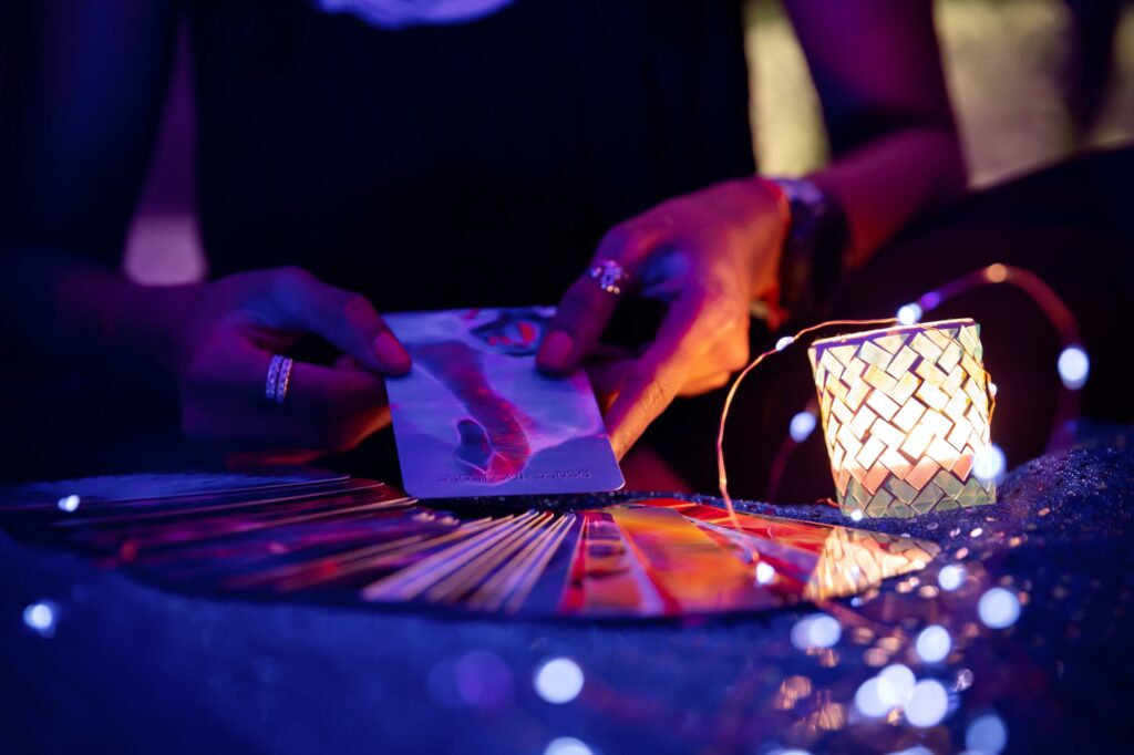 Woman’s hands holding a tarot card with fanned out cards
